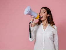 Woman holding megaphone with pink background